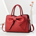 Elegante bolso de mano en cuero texturizado rojo con lazo grande y herrajes dorados - Granate