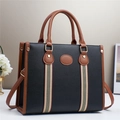 Schwarze Shopper Tasche mit braunem Lederbesatz und gestreiftem Gurt für den Alltag - Schwarz