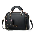 Elegant black leather handbag with cat pendant and gold hardware on white background - 25*10*19 / Black