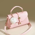 Dettaglio della borsa in ecopelle rosa con ciondolo a bambola e chiusura dorata - Rosa