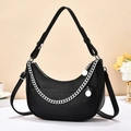 Borsa a spalla nera con catena argento e tracolla regolabile in un ambiente minimalista - Nero