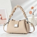 Apricot handbag with pleated ring handle and lychee texture in a minimal setting - Off-white