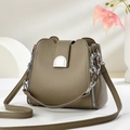 Detailed close-up of khaki pebbled leather bucket bag with silver zipper and chain hardware - Dark Khaki