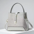 Detalle del bolso tipo cubo en cuero gris claro con encaje floral y cierre dorado - 23x12x21 / Gris