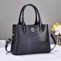 Détail du sac à main bleu marine en cuir verni croco avec logo doré et bandoulière - Bleu