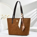 Brown suede tote bag with scarf detail and metal logo in natural window light setting - Earthy Yellow