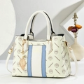 Elegant cream tote bag with blue trim and gold hardware in a minimalist studio setting - Blue