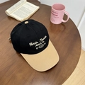 Gorra de béisbol vintage negra y caqui con bordado sobre una mesa de madera - Negro