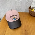 Gorra de béisbol bicolor rosa y negra con bordado de oso sobre mesa de madera - 56-60cm Ajustable / Rosa y Marrón