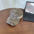 Zerschlissene Baseballkappe mit Leopardenmuster und Stickerei auf einem Holztisch - Leopard Khaki
