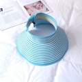 Detail of blue and white striped straw sun hat on white linen with a summer vibe - Blue