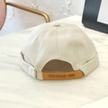 Detail of cream cotton docker hat featuring a brown leather strap with 1986 engraving - Adjustable / Khaki