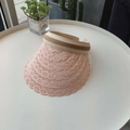 Detail of light pink lace brim and elastic striped strap on a summer sun visor hat - Pink