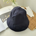 Flat lay of a navy blue foldable sun hat on a table with aesthetic lifestyle props - Navy Blue