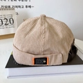 Detail of beige corduroy docker hat featuring a metal buckle and texture close-up - Beige