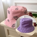Close-up of a pink bucket hat with black butterfly print and neat stitching detail - Pink