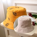 Detail of yellow canvas bucket hat with butterfly print and beige reversible option - Yellow