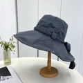 Detail of grey striped sun hat featuring a large bow and woven texture on a wooden stand - 55-59CM / Black