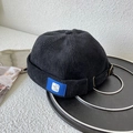 Detalle del gorro docker de pana negra con etiqueta azul y hebilla metálica ajustable - Talla Única(Ajustable) / Negro