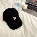 Close-up of black cotton baseball cap with white R embroidery on a lifestyle desk background - 55-59cm (Adjustable) / Black