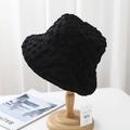 Detailed texture of a black seersucker bucket hat on wood stand with soft lighting - 55-58cm / Black