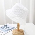 Close-up of white bubble texture bucket hat on wooden stand with detailed fabric view - 55-58cm / White
