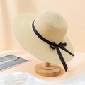 Détail d'un chapeau en paille beige avec ruban noir élégant sur un support en bois naturel - 55-59cm / Beige