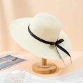 Détail d'un chapeau de paille beige à large bord avec un ruban en soie noir sur support bois - 55-59cm / Blanc Cassé