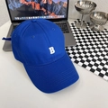 Detail van blauwe katoenen baseballpet met wit B-borduurwerk en versterkte stiksels - Saffierblauw