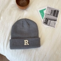 Detail van een grijze gebreide muts met witte letter R patch en zachte ribtextuur - 55-60cm / donkergrijs