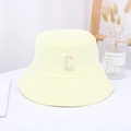 Detail of light yellow cotton bucket hat with white letter C embroidery on white desk - 55-59CM / Yellow