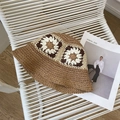 Detail of crochet straw bucket hat with floral patterns on a stylish chair - One Size / Brown