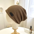 Detail of brown knitted slouchy beanie showing texture and handmade leather label - 56-58cm / Brown