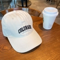Detail of a beige cotton baseball cap featuring black Colorado embroidery on a wooden table - 55-59cm (Adjustable) / Off White