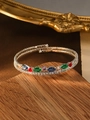 Detalle de brazalete multicapa plateado con circonitas de colores sobre base de madera - Multicolor (Incrustación de Cristal)