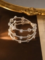 Macro shot of silver-tone triple-layer spiral bracelet with cubic zirconia and pearls - Three-layer Spiral / Silver (Crystal Beads)