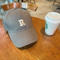 Gorra de béisbol de algodón gris con letra R bordada sobre una mesa de madera rústica - 60-65cm Ajustable / Gris