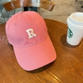 Gorra de béisbol rosa con letra R bordada sobre una mesa de madera con café - 60-65cm Ajustable / Rosa