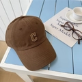 Casquette de baseball marron avec logo C brodé sur une table rayée avec accessoires - 56-58cm Ajustable / Café