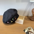 Retro Baskenmütze in Schwarz mit bunten Knöpfen und LABN-Patch auf einem Holztisch - 56-58cm (Verstellbar) / Schwarz