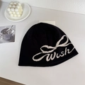 Schwarze Strickmütze mit weißem Wish-Schriftzug und Schleifenmuster auf weiß - 56-58cm / Schwarz