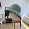 Deep green knitted bucket hat with long ribbons on a wooden mannequin stand - 56-58cm / Green