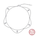Macro detail of S925 sterling silver double-layered anklet with cubic zirconia charms - Silver