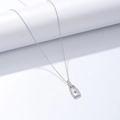 Macro shot of s925 silver lock necklace featuring a pink gemstone and pavé-set zircons - 925 Silver / White