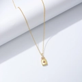 Détail du pendentif cadenas doré avec pierre centrale rouge et éclats de zircons blancs - Argent 925 / Jaune