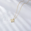 Vintage S925 sterling silver Caesar coin pendant necklace on white draped fabric - 925 Silver / Gold
