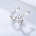 Macro view of S925 sterling silver C-shaped earrings featuring rows of glossy white pearls - 925 Silver / White