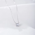 Macro shot of brilliant round-cut zircon pendant with four-prong setting on silver chain - 925 Silver / Silver