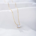 Detailed view of a round cubic zirconia pendant on a thin gold-plated sterling silver chain - 925 Silver / Gold