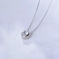 Gros plan d'un collier minimaliste en argent sterling 925 avec un zircon rond étincelant - Argent 925 / Blanc